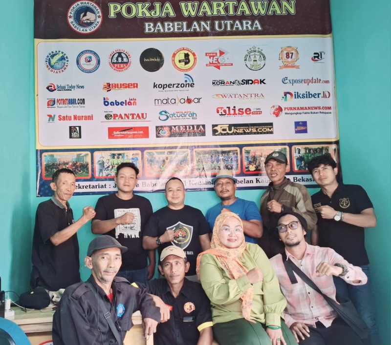 Ketua Persatuan Wartawan Indonesia (PWI) Bekasi Raya, Ade Muksin, SH., berdiri di belakang dengan memakai kaos hitam ada logo besar  PWI,  menyambangi kantor Sekretariat Kelompok Kerja (Pokja) Wartawan Babelan Utara