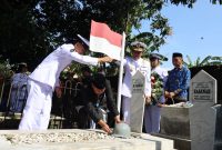 Wali Kota Bekasi Tri Adhianto bersama Wakil Wali Kota Bekasi Abdul Harris Bobihoe melakukan prosesi penyematan helm pahlawan di makam tokoh perjuangan Kota Bekasi, M. Hasibuan